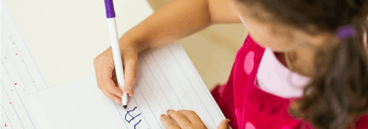 Enfant en train d'écrire sur une feuille 