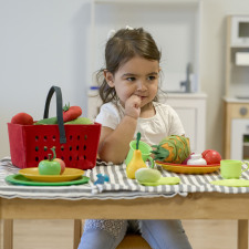 Enfant jouant avec une dinette en tissu